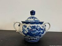 Front view of blue and white porcelain pot showing floral pattern and handles