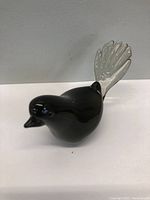 Front angle of the black Murano glass bird figurine showing details of the beak and body shape