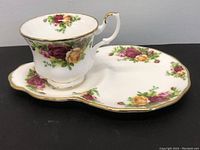 Side view of tea cup and saucer showing floral pattern and gold trim