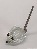 Full view of Swarovski crystal mouse figurine showing clear faceted body, black eyes and nose, and grey tail.
