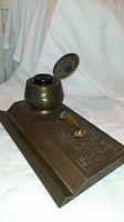 Side angle showing the bronze desktop set with the inkwell lid open revealing black bakelite ink holder and the pen holder with green felt tip.