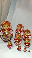 Full set of 9 Russian nesting dolls arranged upright to show faces and bodies