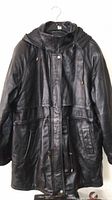 Front view of the mens black leather coat with hood and drawstrings visible.