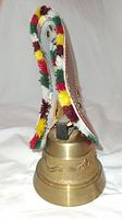 Brass cowbell with colorful woven leather strap and brass animal and landscape decorations from Switzerland.
