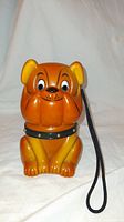 Front view of the orange cartoon bulldog AM radio that shows the dog's face and attached wrist strap.