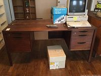 Full view of vintage wooden desk with drawers and inserts, parts showing wear and an old computer setup on top for scale