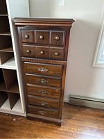 Front view of tall wooden lingerie cabinet showing six lower drawers with metal handles and six smaller upper drawers with wooden knobs.
