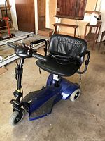 Blue Travel Pal mobility scooter showing right side view with black cushioned seat and armrest.
