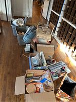 Long angle photo showing bins, boxes, and folded fabrics with various sewing and craft supplies grouped for sale.
