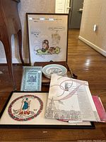 Virginia-themed lot including framed cartoon pilot poster, 1931 telephone almanac, colorful Homer Laughlin plates, government poster booklet, and other ephemera laid out on floor.