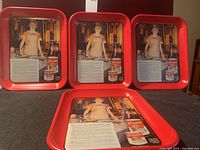 Four new red tin trays with vintage Carnation Evaporated Milk ad showing a woman in an apron and product images.