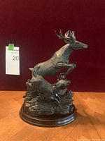 Front-side view of two running deer statue showing detail and damage