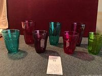 Full set of eight jewel tumblers in assorted colors arranged on fabric with tag