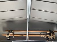 Full view of vintage wooden roof rack showing two long wooden beams connected with straps and rubber suction cups at ends and center.