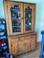 Front view of entire cabinet showing upper glass doors, lower solid doors and drawers