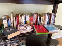 A shelf with a collection of novels and books including fiction, erotica, and an Andy Warhol book.
