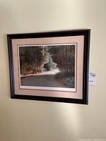 Overall view of the framed print showing forest path and trees in black frame.