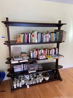 Full view of large wooden shelving unit with books and various items on shelves (contents not included).