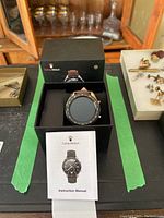 Oshen Watch smartwatch in black box with instruction manual visible in front