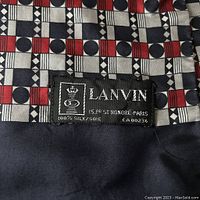 Close-up of the Lanvin Paris label sewn onto the scarf, showing 100% silk material and address.