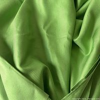 Close-up of apple green silk fabric showing texture, weave, and slight sheen.