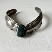 Front view of MCM-style thick silver neck choker with green agate oval stone in center, showing overall design and condition.