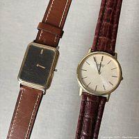 Pair of vintage Seiko watches showing the square black dial watch and round white dial quartz watch with new leather straps.