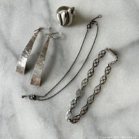 Lot laid out on marble surface showing all jewelry items: earrings, ring, bracelet, and necklace.