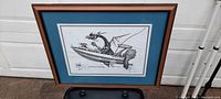 Full view of framed art print showing dragon in speed boat with blue mat and solid wood frame.
