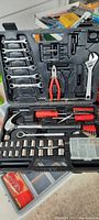 Overview of Craftsman tool set in black molded case showing wrenches, pliers, adjustable wrench, socket wrenches, screwdrivers, bits, and fasteners.