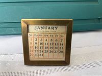 Square metal frame with brass finish holding a January calendar card for 31 days.