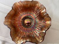 Top view showing the ruffled edge and radial texture of the marigold carnival glass bowl with rainbow iridescence.