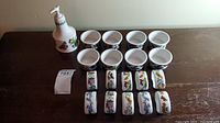 Photo showing all items in the set including the hand soap dispenser, dipping bowls, and napkin rings arranged on a wooden surface.