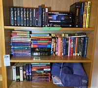 Photo of three shelves filled with multiple books including Ian Rankin novels and assorted other fiction titles