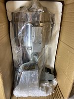 Main grinder unit packed in foam and plastic wrap inside box