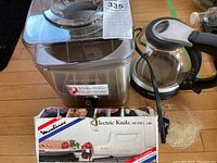 View of Cuisinart ice cream maker with control knob, Prestige electric kettle with glass body and black handle, and Moulinex electric knife box showing branding and model.