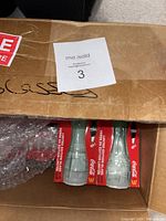 Box containing the 18 limited edition Coca-Cola glasses in original packaging with McDonald's branding.