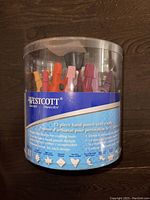 Front view of the Westcott 12-piece hand punch craft set in its round clear plastic caddy showing product labeling.
