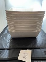 Stack of 12 paper gift baskets showing ribbed beige exterior