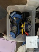 Top view of the container with snorkeling gear sets packed inside, showing two blue adult sets with masks, snorkels and carrying bags.