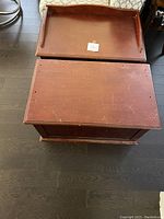 Top-down view of two wooden toy chests, one with the lid detached and missing a top ledge piece, showing surface wear and scratches.