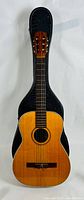 Full view of vintage Goya acoustic guitar standing in original black hard case