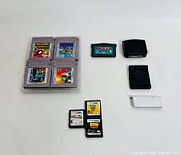 Lot photo showing 4 original GameBoy cartridges, one GameBoy Advance cartridge, GameBoy Advance Lite slot placeholder, Nintendo 64 cartridge, and PlayStation 2 memory card