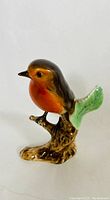 Front view of the robin red breast figurine showcasing the bird perched on a branch with detailed coloration and glazing.