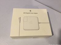 Closed white box of Apple 60W MagSafe Power Adapter showing front product image on box.
