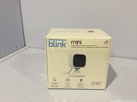 Front view of the unopened box showing the Blink Mini camera and key features.