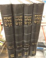 Four volumes of Hebrew Dictionary with gold embossed Hebrew lettering on black hardcover spine.