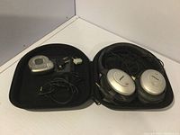 Bose over-ear noise cancelling headphones and accessories inside zippered case