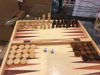 Wooden chess and backgammon set with chess pieces arranged and backgammon board shown open with pieces and dice.