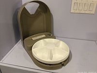 Image showing the full Pet Safe automatic pet feeder with round white 5-compartment rotating tray and beige plastic body.